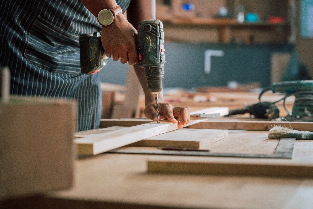 Person drilling a screw into a piece of wood.