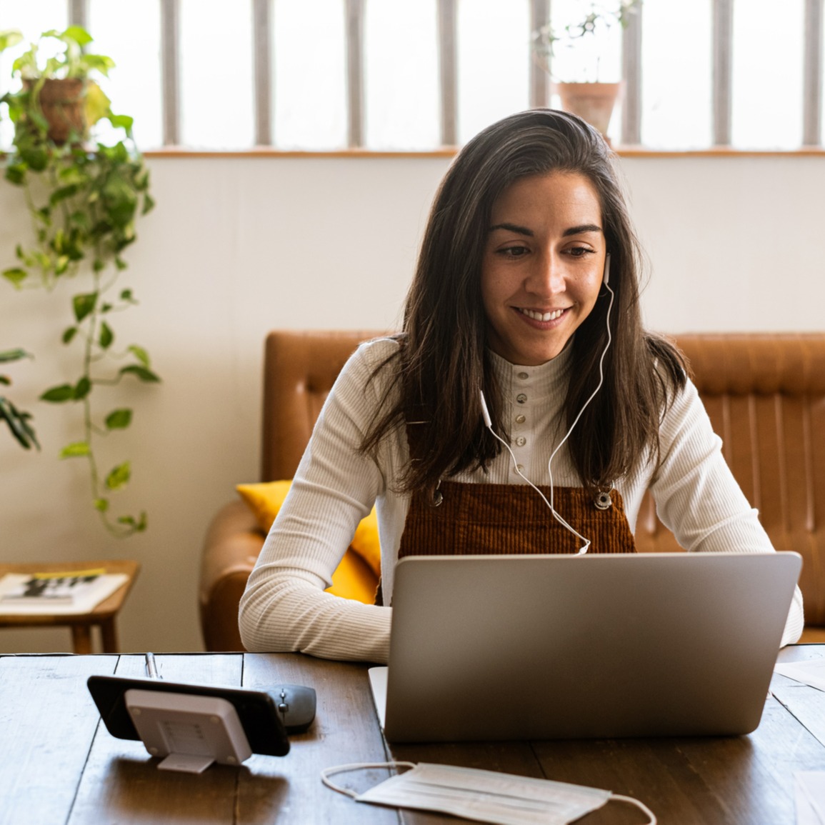 Woman listening to headphones and reading something on her computer