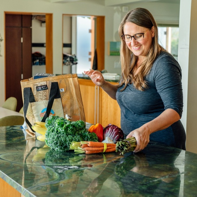 A person unpacking groceries in their kitchen