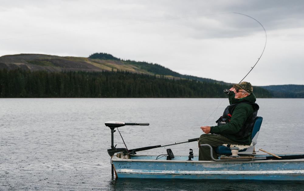 Man fishing in boat on lake